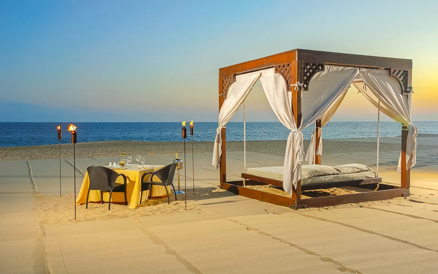 Beach cabana set for dinner at sunset